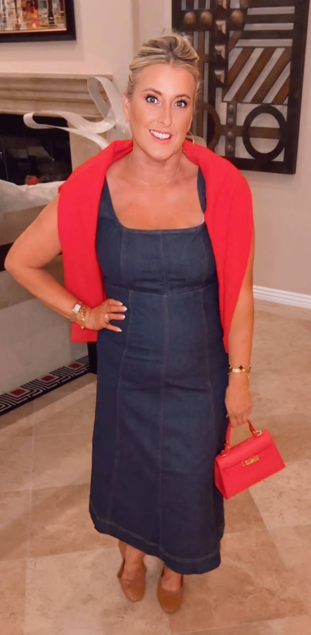 Denim midi with red sweater draped over shoulders