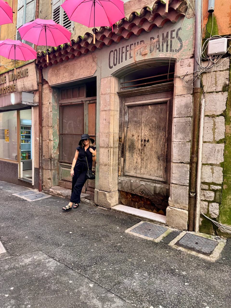 Linda on a street in France with a floppy hat
